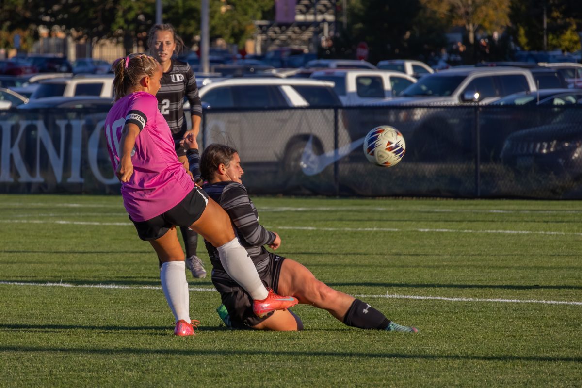 In an attempt for a goal, third-year Sami Webster kicks the ball over a University of Dubuque athlete. Photo by Ali Parkhurst