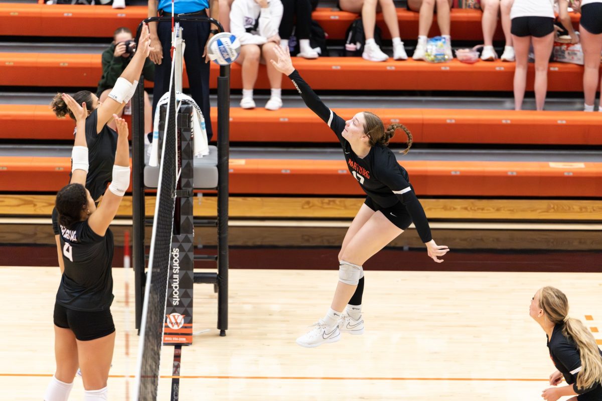 Sophomore Anna Sash swings for a kill against Augsburg University on Sept. 27. Photo courtesy of Julie Drewes, Marketing and Communication.