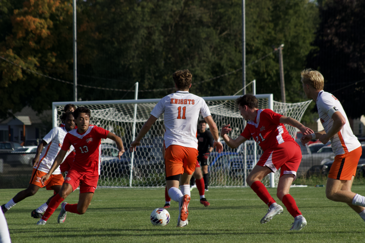 Senior Landon Hartsell dribbles around defenders from the Milwaukee School of Engineering on Sept. 13. Photo courtesy of Madi Petersen, The Wartburg Trumpet. 