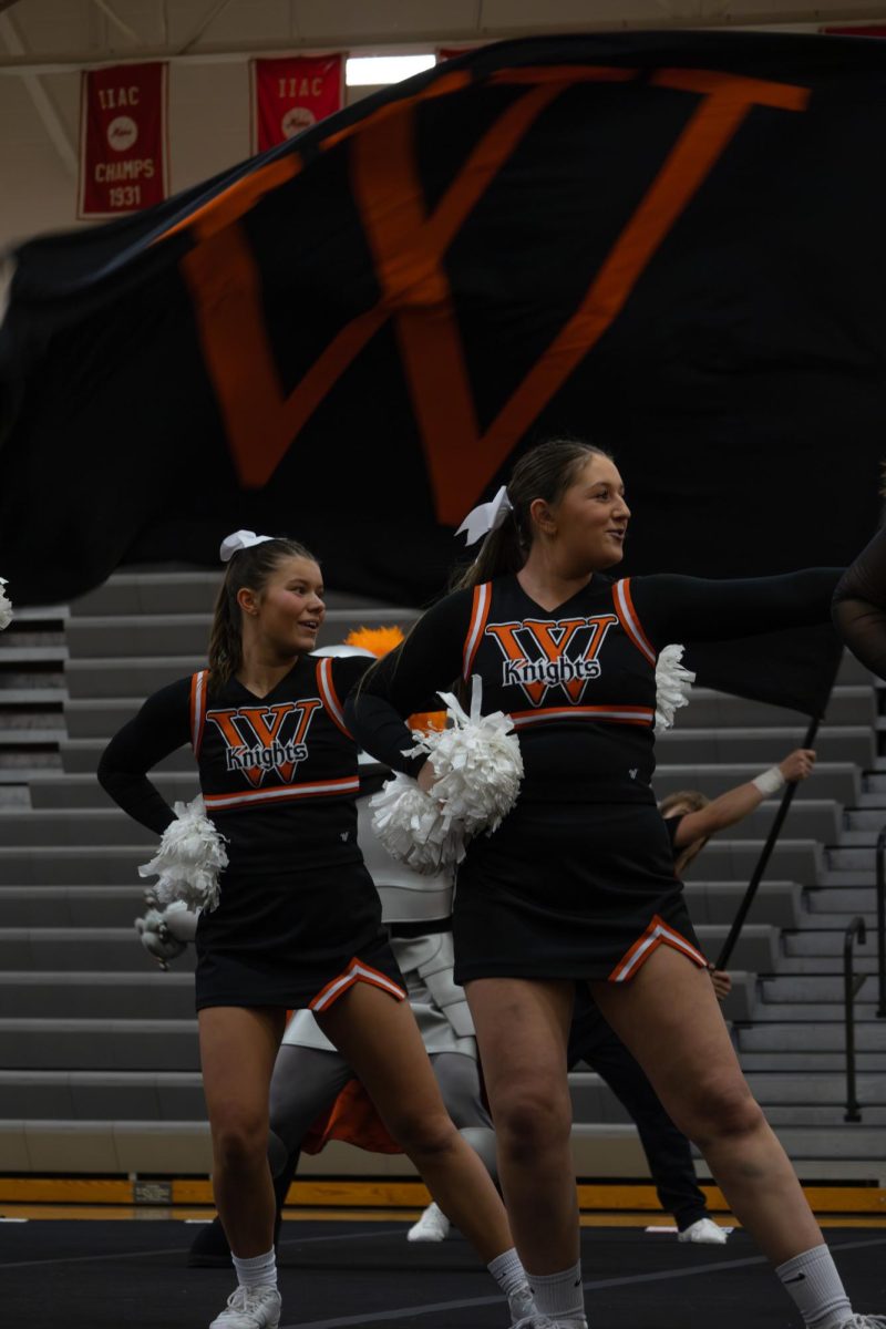 Wartburg Cheer team member's looking off to the side during the game day routine. 