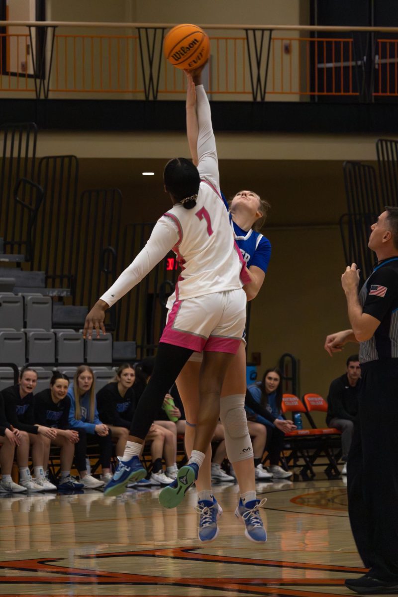 During the tipoff, junior Corrie Harrison jumps for the ball.