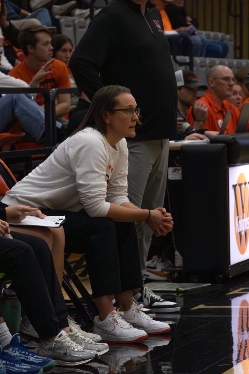 Assistant Coach Kelley Jacobs watches the game from the sidelines.