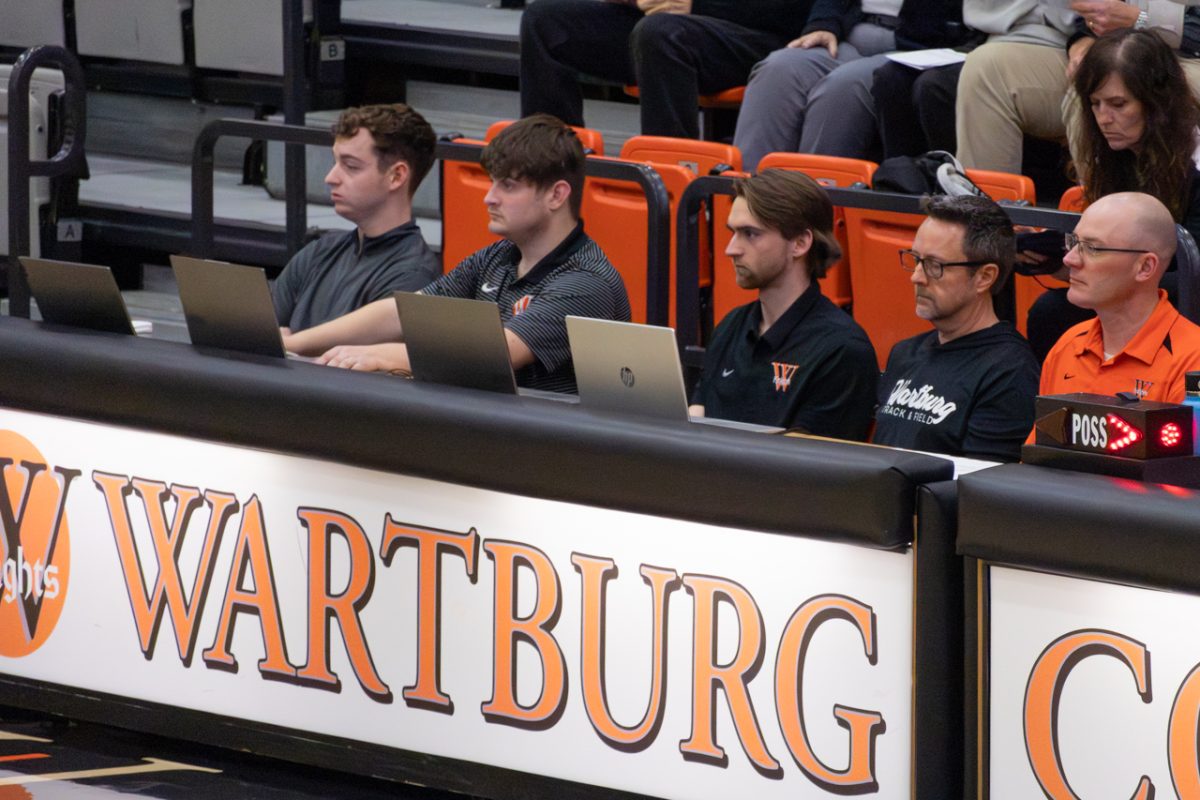 Carter Bornemeier (middle) keeps track of statistics during a Wartburg Men's Basketball game on Nov. 14, 2025.