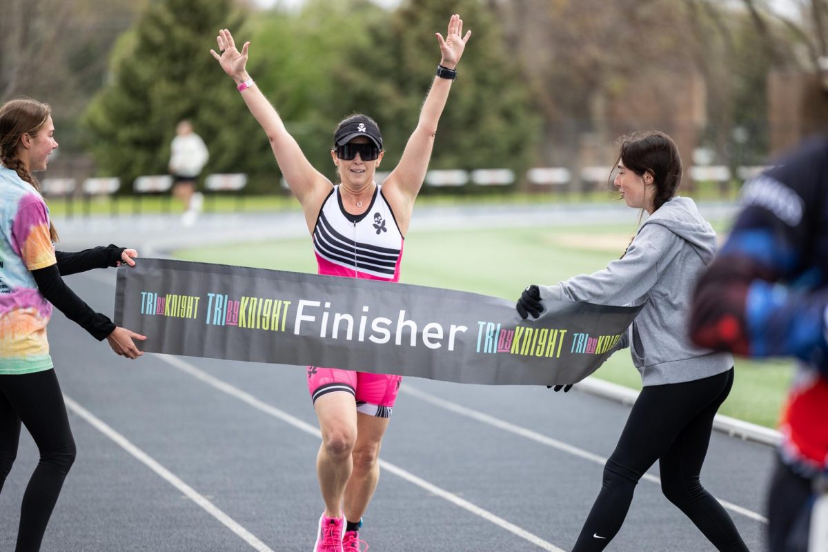 TriByKnight participant crosses the finish line on the track of the Walston Hoover Stadium. 