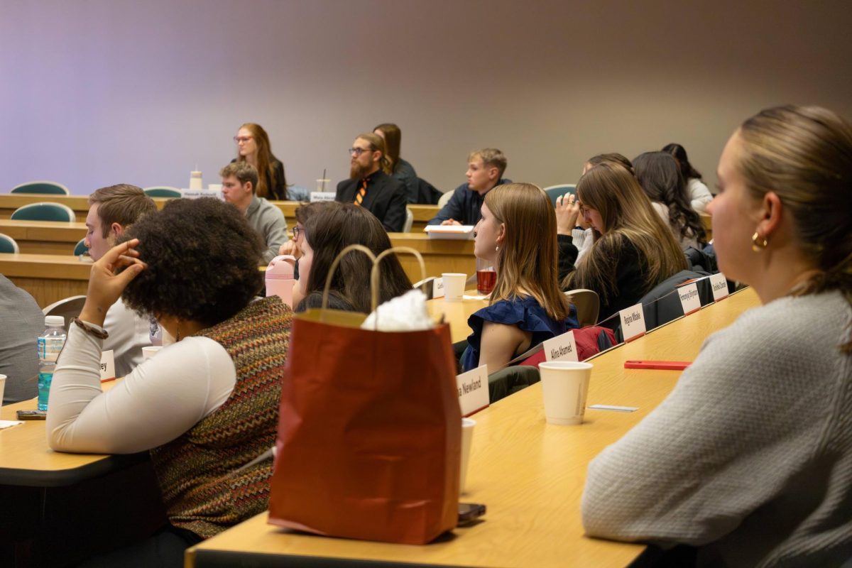 Student senators in a meeting listening to details and taking notes.
