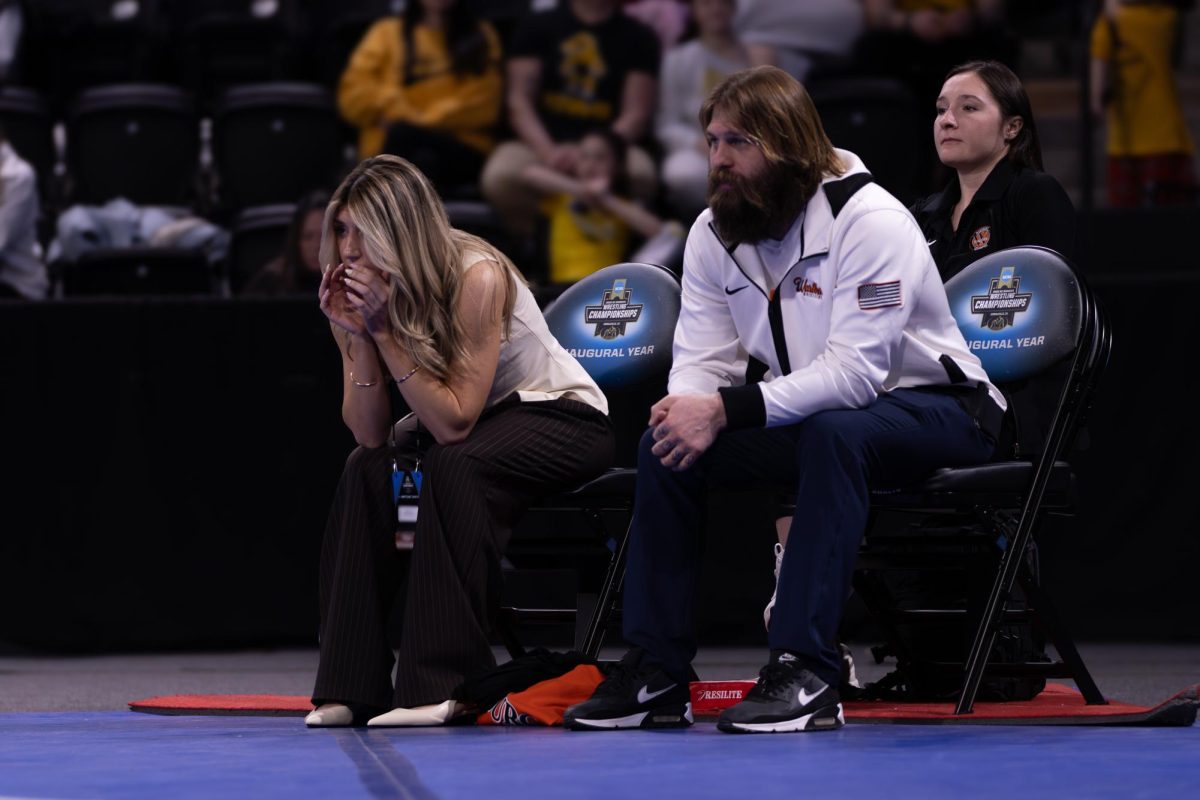Assistant Coaches Gunner Wolfensperger and Sami Lusk cheer on Kylie Rule from the sidelines of her match. 