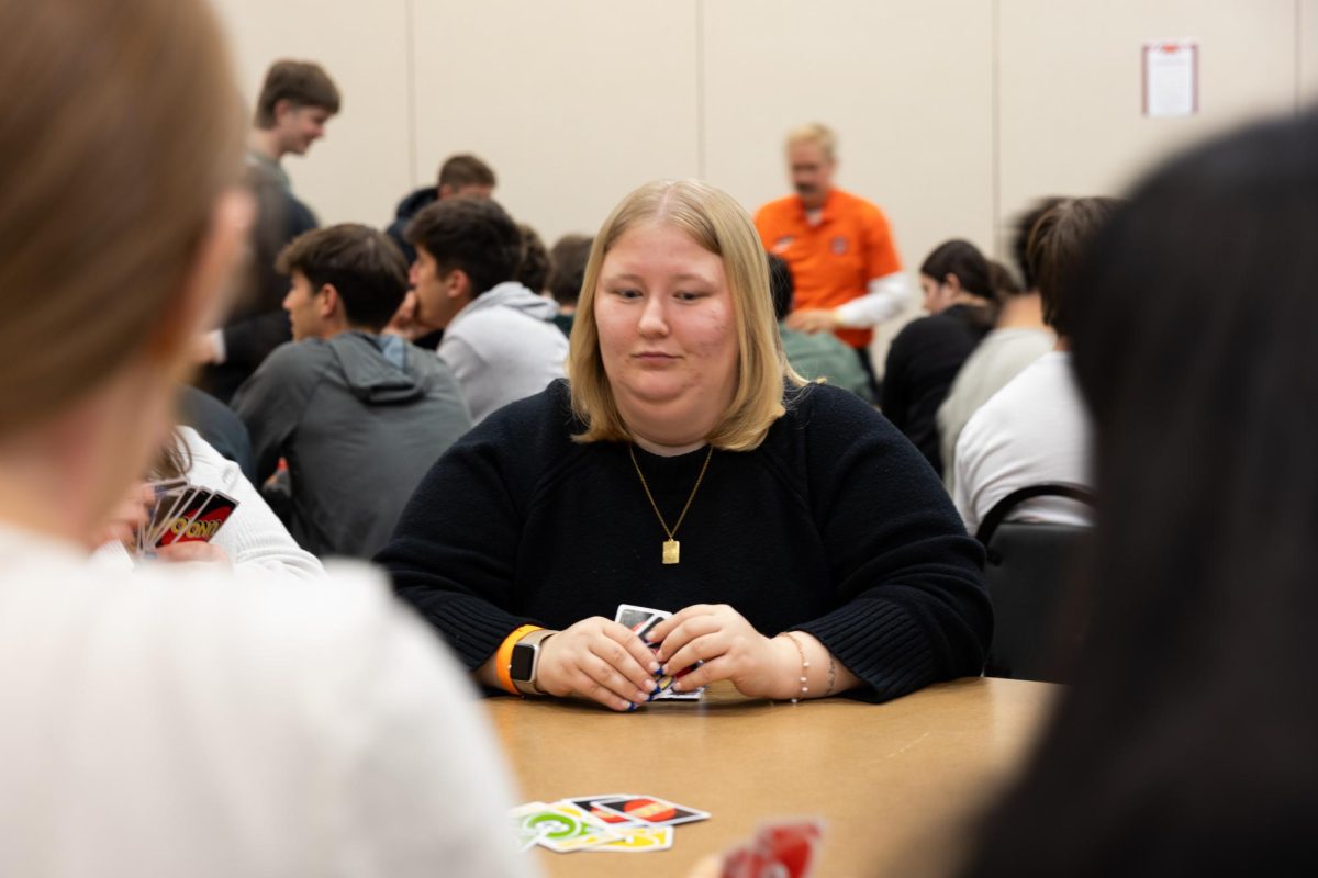 The student is strategizing her new move in the game of UNO. 