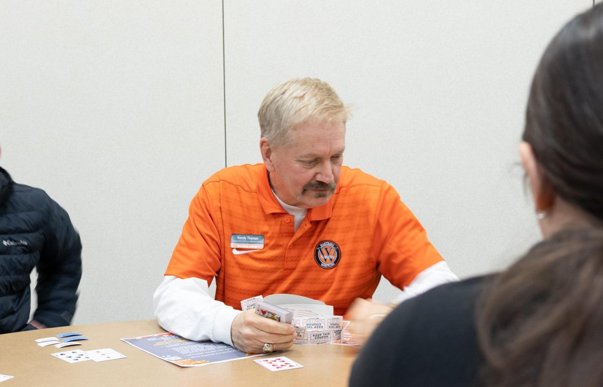 Randy Thomas is dealing a card game during Casino Night. 