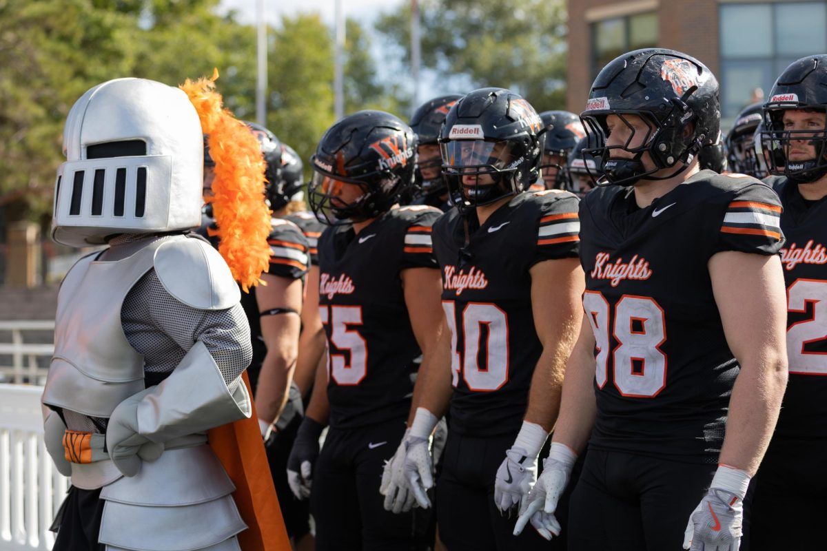 Junior Jake Walker (right) prepares to run into Walston-Hoover Stadium with the Wartburg Football team for the 2026 homecoming game.