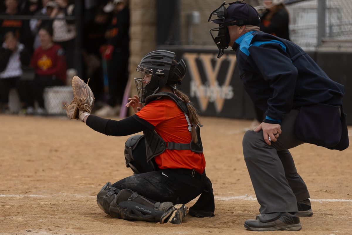 Senior Alexis Larson sits behind home plate, waiting for a pitch from her teammate.  